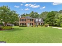 Traditional two-story brick home with a well-manicured lawn and mature trees at 127 Rockspray Rdg, Peachtree City, GA 30269