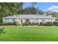 Charming single-story home featuring a manicured lawn and nicely trimmed shrubs at 85 London Ln, Sharpsburg, GA 30277