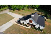 Aerial view of a modern barn style home with black roof and white siding at 540 Benton Rd, Covington, GA 30014
