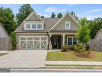 Charming two-story home featuring a two-car garage, covered porch, and a well-manicured front yard at 400 Plainfield St, Fayetteville, GA 30215