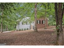 Charming home featuring a mix of brick and siding, nestled among mature trees and lush foliage at 161 Bradford Pl, Stockbridge, GA 30281