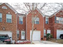 Charming brick townhome featuring a one-car garage and a welcoming front entrance at 6517 Snowbird Ln, Douglasville, GA 30134