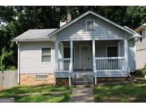 Charming bungalow with a covered front porch, stone foundation, and mature trees at 1627 Orlando Sw St, Atlanta, GA 30311