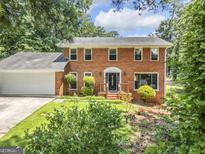 Charming brick home featuring well-maintained landscaping, a manicured lawn, and a welcoming front entry at 708 Delanie Way, Stone Mountain, GA 30083