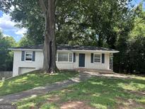 Charming brick home featuring a well-maintained lawn and beautiful mature trees for added curb appeal at 3129 Se Nursery Se Rd, Smyrna, GA 30082