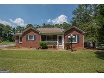 Charming brick home with a welcoming screened front porch and manicured lawn at 611 Bernhard Rd, Fayetteville, GA 30215