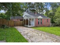 Charming brick home with a covered front porch and a driveway at 3260 Russell St, Hapeville, GA 30354