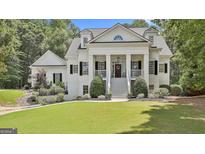 Charming white home featuring a columned porch, black shutters, and professionally landscaped front yard at 275 Sidney Ln, Fayetteville, GA 30215
