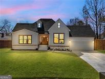 Charming white brick home with a well-manicured lawn, complemented by a gray roof and inviting front entrance at 1774 Vesta Ave, Atlanta, GA 30337