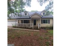 Charming home featuring dormer windows, a welcoming front porch, and a well-manicured lawn at 195 Wellington Dr, Mcdonough, GA 30252