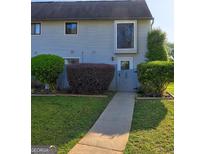Charming townhome with well-maintained landscaping and inviting walkway to the front door at 288 Country Club Dr, Jonesboro, GA 30238