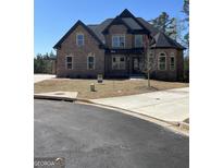 Stunning two-story brick home with black roof, manicured lawn, and modern architectural details at 987 Kora Sw Dr, Marietta, GA 30064