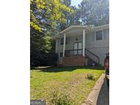 Charming two-story home with a covered front porch, lush lawn, and a welcoming entrance at 60 Victoria Dr, Ellenwood, GA 30294