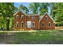 Charming brick two-story home with a symmetrical facade and a lush green lawn at 1783 Cheyenne Trl, Jonesboro, GA 30236