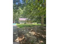 Charming home featuring a fenced yard and mature trees providing shade and curb appeal at 921 Hightower Trl, Oxford, GA 30054