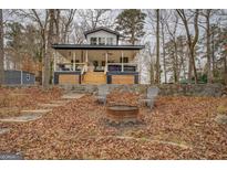 Charming exterior of home featuring a cozy front porch with outdoor seating, fire pit, and wooded surroundings at 480 Mitchell Rd, Covington, GA 30014