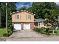 Charming two-story home featuring a two-car garage, brick accents, and a well-maintained front yard at 4402 Auburn Hills Drive, Stone Mountain, GA 30083