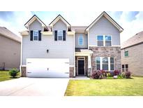 Two-story house with gray siding, stone accents, and a two-car garage at 5550 Rialto Way, Cumming, GA 30040