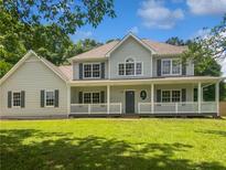 Charming two-story home featuring a covered front porch and beautifully landscaped front yard at 225 Woodfield Ct, Mcdonough, GA 30253