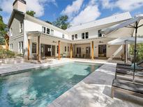 Backyard pool and patio area featuring lounge chairs and outdoor seating beneath a covered porch at 230 Pebble Trl, Alpharetta, GA 30009