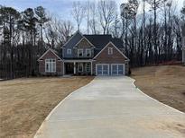 Beautiful brick and stone two-story home with a three-car garage and long concrete driveway at 1114 Low Water Crossing, Acworth, GA 30101