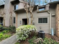 Neutral two-story townhome featuring mature landscaping and a stone walkway leading to the front door at 3510 Stonewall Se Pl, Atlanta, GA 30339
