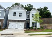 Charming two-story home with stone accents, white garage door and a well-manicured lawn at 360 Lakeside Ct, Canton, GA 30114