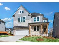 Charming two-story home featuring a brick facade, inviting front porch, and a two-car garage at 3025 Sunset Pass, Canton, GA 30114