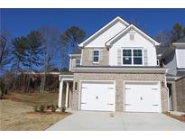 Two-story home with gray brick and white accents, two-car garage, and landscaping at 1151 Park Center Cir, Austell, GA 30168