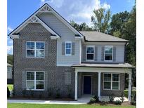 Beautiful two-story home featuring a brick facade, gray siding, covered porch, and manicured front lawn at 558 Abbott Se Ct, Atlanta, GA 30354