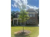 Charming brick home with a well-manicured lawn and a newly planted tree in the front yard at 565 Abbott Se Ct, Atlanta, GA 30354