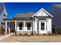 Charming home featuring a welcoming front porch with brick accents and manicured landscaping at 498 Pearl St, Cumming, GA 30040