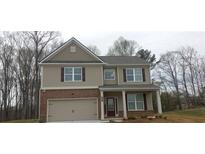 Two-story home featuring a brick-and-siding facade, a two-car garage, and a welcoming front porch with supporting columns at 6035 Spring Way, Stonecrest, GA 30038