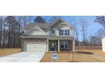 Charming two-story home with stone accents, a two-car garage, and a well-maintained front yard at 6045 Spring Way, Stonecrest, GA 30038