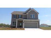 Charming two-story home with a two-car garage and gray siding, perfectly complemented by a well-manicured lawn at 6048 Spring Way, Stonecrest, GA 30038