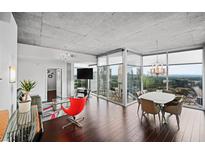 Bright living room with hardwood floors, modern furnishings, and floor-to-ceiling windows with city views at 3324 Peachtree Ne Rd # 2718, Atlanta, GA 30326