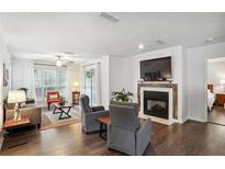 Comfortable living room featuring a fireplace, neutral paint, and wood flooring throughout the space at 609 Mill Pond Se Dr, Smyrna, GA 30082