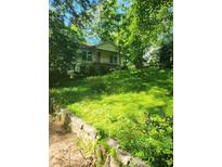 Charming bungalow-style home with a lush green yard and mature trees providing ample shade at 3534 Sw Boulder Park Sw Dr, Atlanta, GA 30331