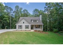 Craftsman style home with gray siding, landscaping, and driveway at 939 Jean Ct, Covington, GA 30014