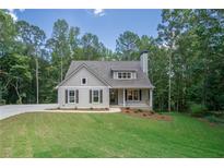 Charming one-story house with gray siding, a large yard, and a tree-lined backdrop at 939 Jean Ct, Covington, GA 30014