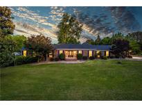 Beautiful brick home featuring a sprawling green lawn, mature trees, and a welcoming front entrance at 3700 Tom Brewer Rd, Loganville, GA 30052