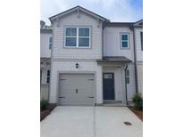 Modern two-story townhome with gray siding, attached garage, and concrete driveway at 5895 Mattan Trl, Lithonia, GA 30058