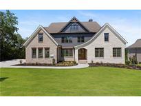 Two-story home with brick and stone accents, and a lush green lawn at 5693 Brendlynn Dr, Suwanee, GA 30024