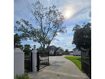 Beautiful property featuring a gated entrance with a circular drive leading to the main house and lush green lawns at 3898 Ridge Rd, Buford, GA 30519