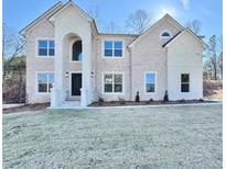 Two-story house with brick facade, arched entryway, and landscaped lawn at 179 Basie Ct, Fairburn, GA 30213