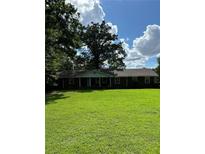 Brick ranch house with a large front yard and mature trees at 5595 Stagecoach Rd, Rex, GA 30273