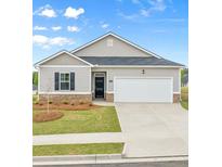 Charming single-story home featuring a manicured lawn, two-car garage, and classic architectural details at 8593 Preakness Pass, Lithonia, GA 30058