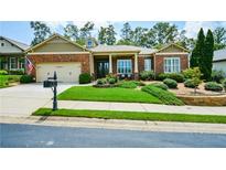 Charming brick home featuring a well-manicured lawn and an inviting covered entryway at 705 Springer Mountain Dr, Canton, GA 30114
