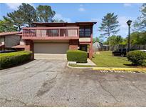 Inviting two-story home with a balcony, garage, and well-maintained landscaping at 1084 Village Main St, Stone Mountain, GA 30088