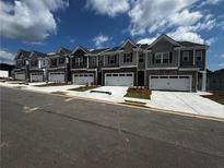 Row of new townhomes with attached garages and modern gray and stone facade, inviting curb appeal at 338 Elgin Dr, Lawrenceville, GA 30045